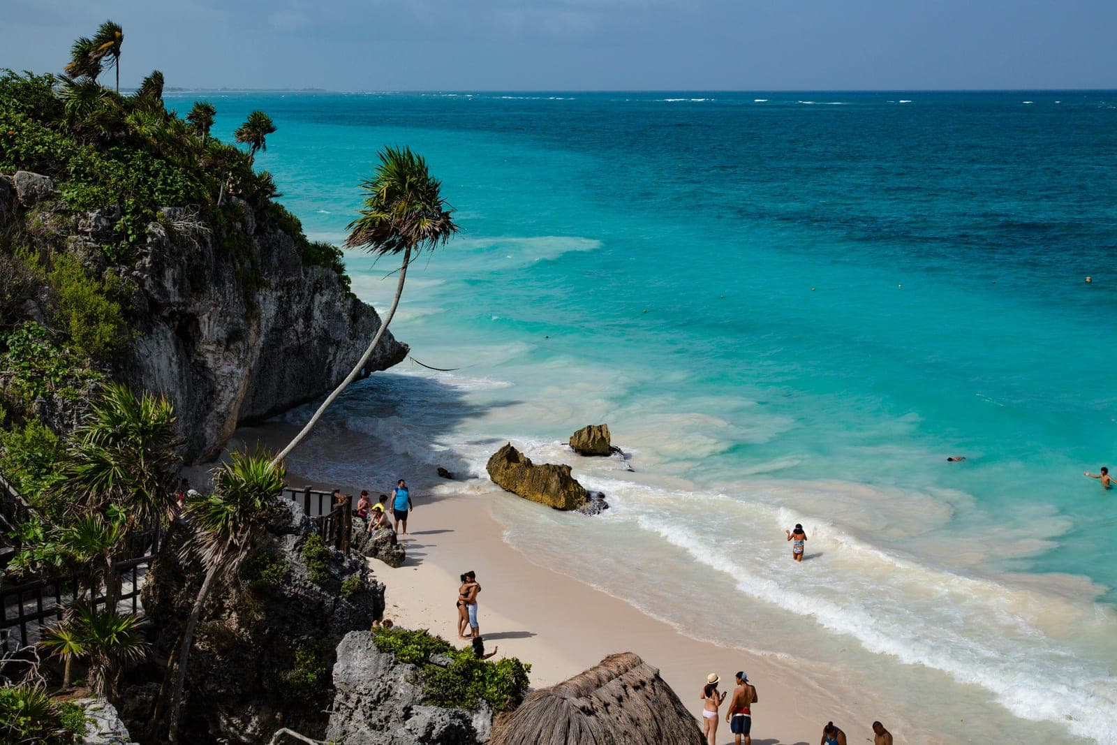 Tulum beachfront with palm trees and boutique resort architecture